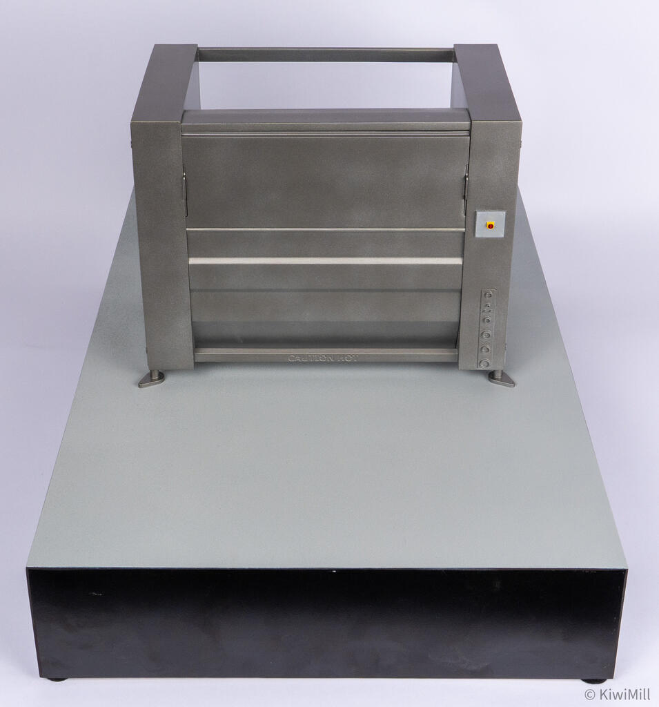 High rear view over the long display base showing the chiller's open top frame and CAUTION HOT lettering